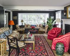 a living room with couches, chairs and rugs in front of two windows