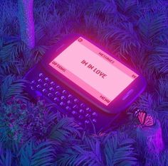 an old typewriter sitting in the middle of some trees with purple light on it