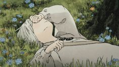 a woman laying in the grass with her head on her hand and eyes closed, as if she were kissing someone