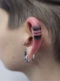 a woman with ear piercings has pink and black stripes on her ears as if they were fake