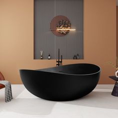 a large black bath tub sitting on top of a white floor next to a chair