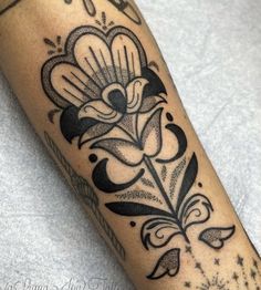 a black and white flower tattoo on the arm