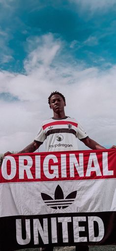 a man holding up a sign that says original united