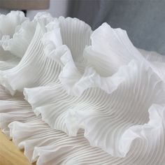 a close up view of some white fabric on a bed sheet that is folded over