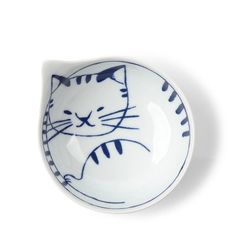 a blue and white bowl with a cat design on the front, sitting on a white surface