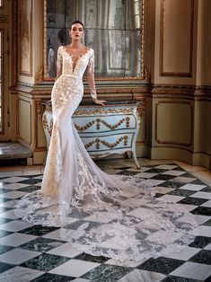 a woman in a wedding dress standing on a checkered floor with a mirror behind her