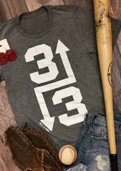 a t - shirt with the number thirteen on it next to some baseball mitts