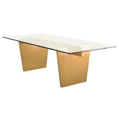 a glass and gold dining table with two legs