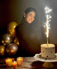 a woman sitting in front of a birthday cake