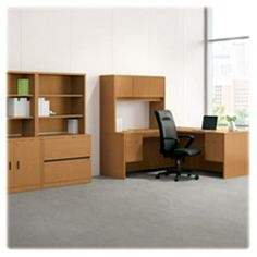 an office cubicle with desk, bookcase and chair