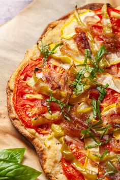 a pizza topped with lots of toppings on top of a wooden cutting board