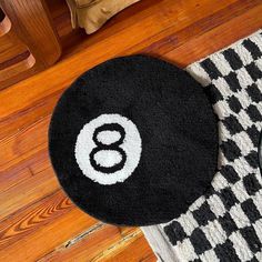 a black and white rug sitting on top of a wooden floor next to a table