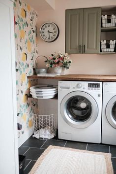 a washer and dryer in a small room with floral wallpaper on the walls