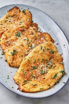 two pieces of food on a plate with parmesan cheese and seasoning sprinkles