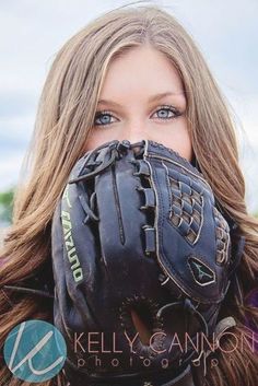 a woman wearing a catchers mitt and covering her mouth