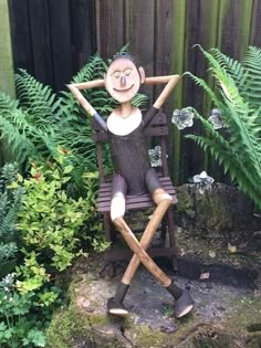 a wooden sculpture of a man sitting in a chair with his hands behind his head