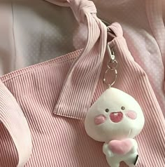 a stuffed animal keychain attached to a pink shirt