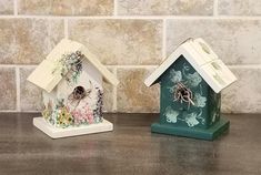 two ceramic bird houses sitting on top of a counter