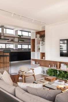 a living room filled with furniture and a flat screen tv mounted on the wall above it