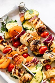 grilled vegetables and meat on a white platter