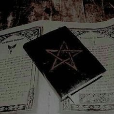 an old book with a pentagramil on it sitting on top of a table