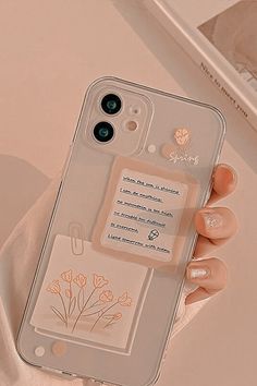 a woman's hand holding an iphone case with flowers and a tag on it