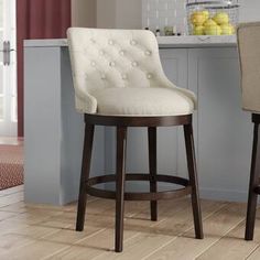 two bar stools sitting in front of a kitchen counter