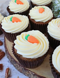 cupcakes with white frosting and carrot decorations