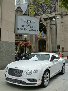 a white car is parked in front of bentley's gold coast