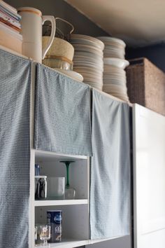 the kitchen cabinets are covered with blue and white fabric, which is hanging from the ceiling