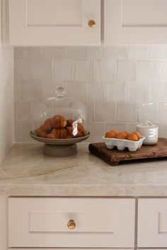 a bowl of oranges sitting on top of a counter next to a plate of food