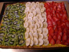 an assortment of sliced fruit arranged in the shape of a flag on top of a pastry