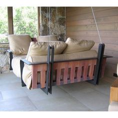 a couch sitting on top of a wooden floor next to a stone wall and window