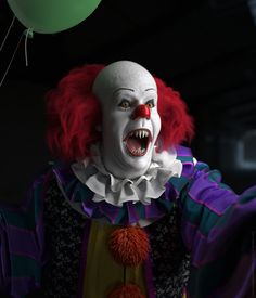 a creepy clown with red hair and white teeth holding a green balloon in the air