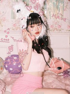 a young woman sitting on top of a bed wearing a pink skirt and headband