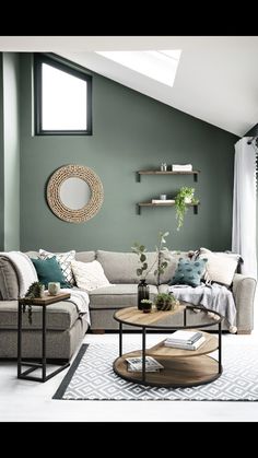 a living room with green walls and white rugs on the floor, two couches in front of a round coffee table