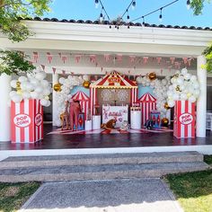 an outdoor stage set up for a circus themed birthday party with balloons and confetti