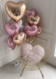 a bunch of heart shaped balloons sitting on top of a chair