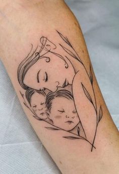 a woman's arm with a drawing of two children and a leaf on it