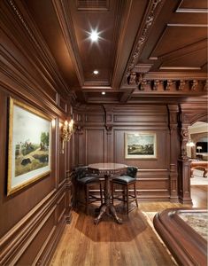 an elegant dining room with wood paneling and wooden flooring, along with paintings on the walls