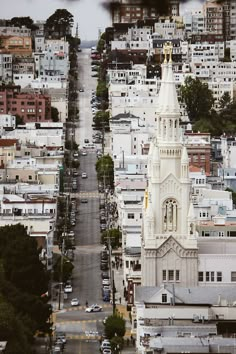 an aerial view of a church steeple in the middle of a city with lots of tall buildings