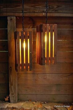 two wooden lights hanging from chains on a wall