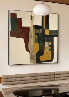 an abstract painting hangs on the wall above a dining room table with chairs and couches