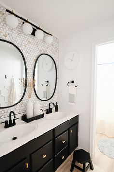 a bathroom with two sinks and mirrors on the wall