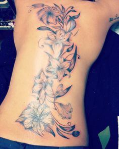 a woman's lower back tattoo with flowers on it