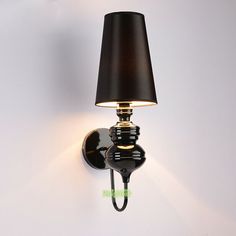 a wall light with a black shade on it's side and a white background