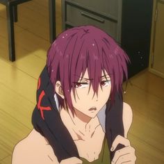 a man with purple hair sitting on the floor