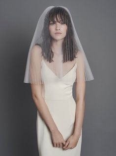 a woman in a white dress with a veil over her head