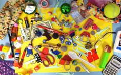 various crafting supplies laid out on a yellow tablecloth with scissors, buttons and other items