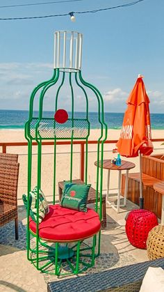 a birdcage sitting on top of a sandy beach next to the ocean